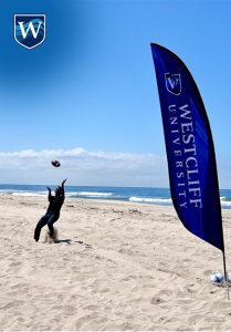 Westcliff University Student Life beach day, Huntington Beach. Students playing football