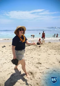 Tayler Henslick walking on beach at student life event, Westcliff University